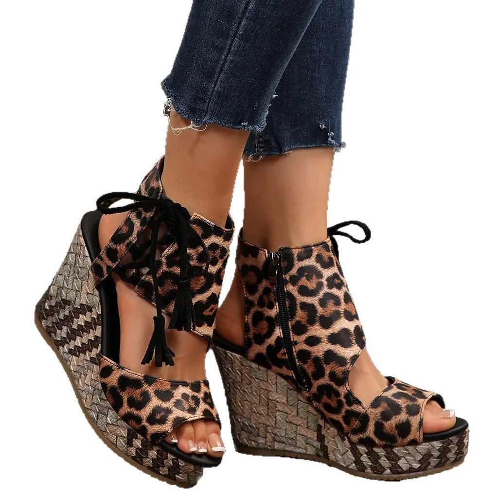 Leopard print wedge sandals worn with rolled-up jeans on a white background