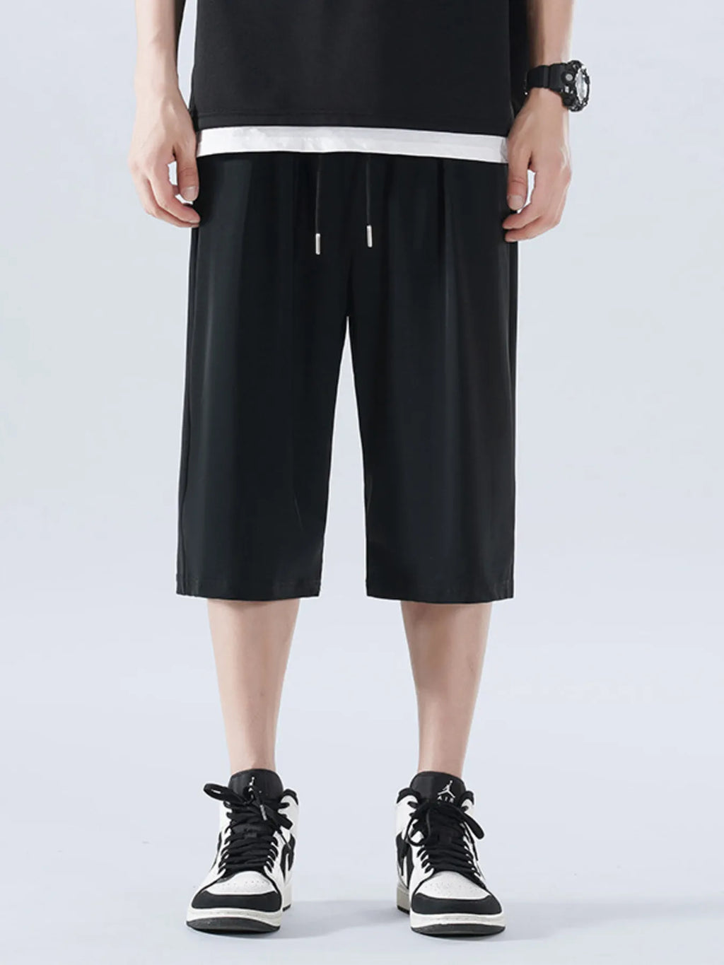 Person wearing black shorts and black sneakers on a white background-Blackorvani