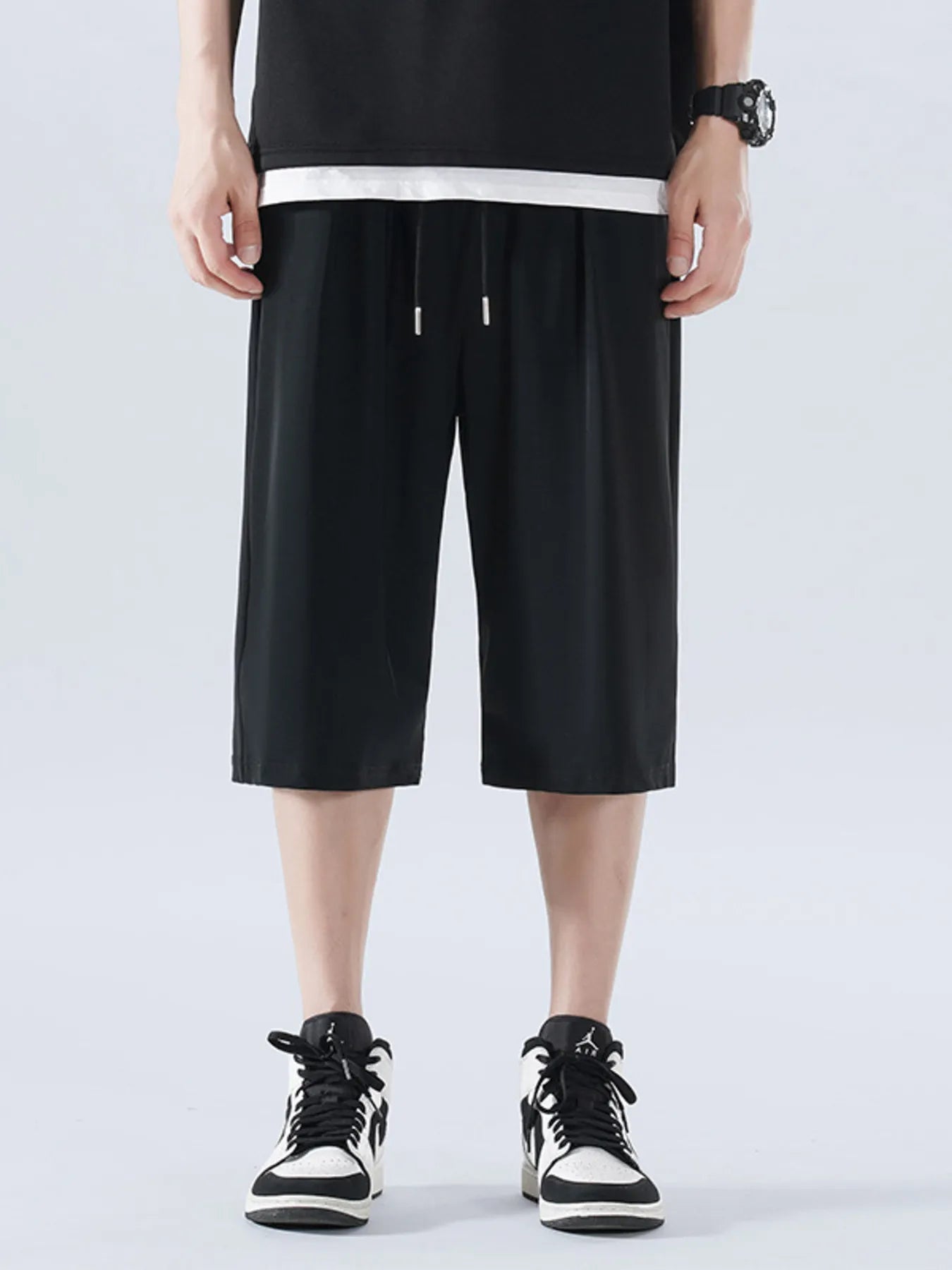 Person wearing black shorts and black sneakers on a white background-Blackorvani