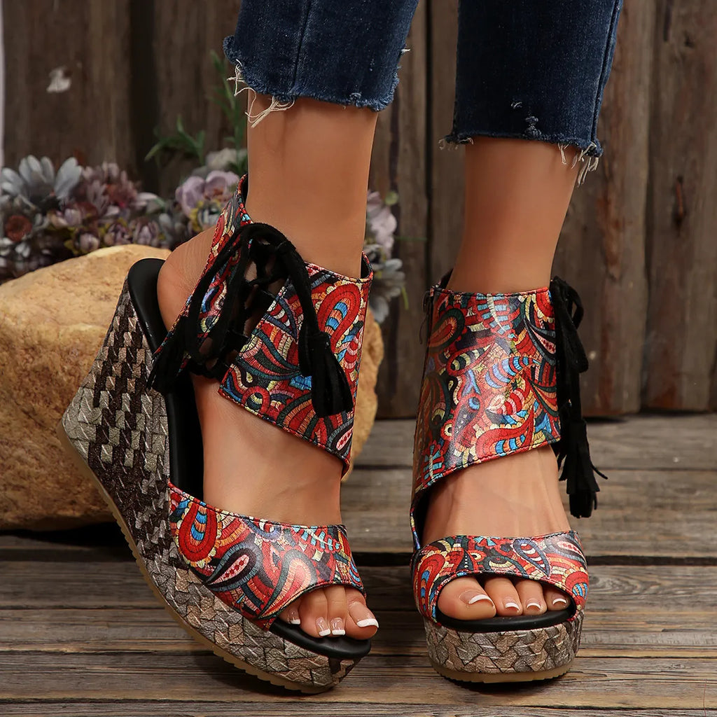 Colorful patterned wedge sandals on a wooden floor with floral background
