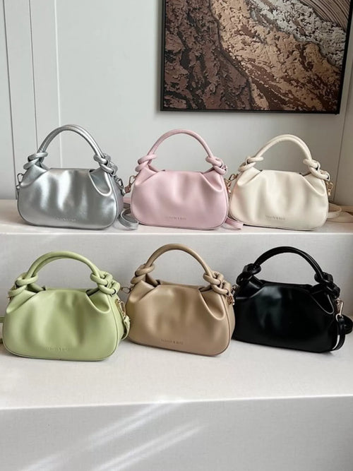 Six handbags in different colors displayed on a shelf-blackorvani
