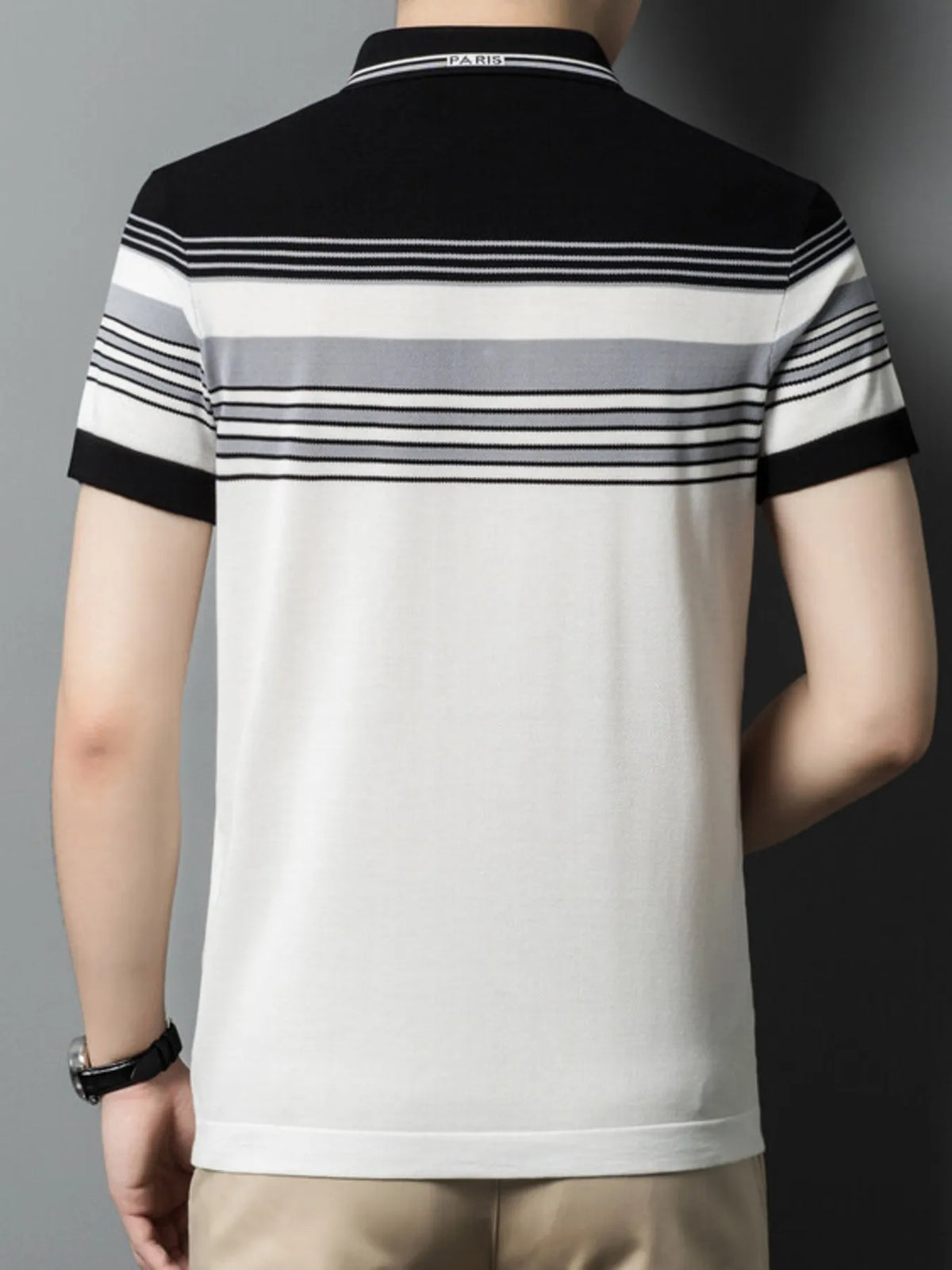 Person wearing a black and white striped polo shirt with a gray background-blackorvani.com