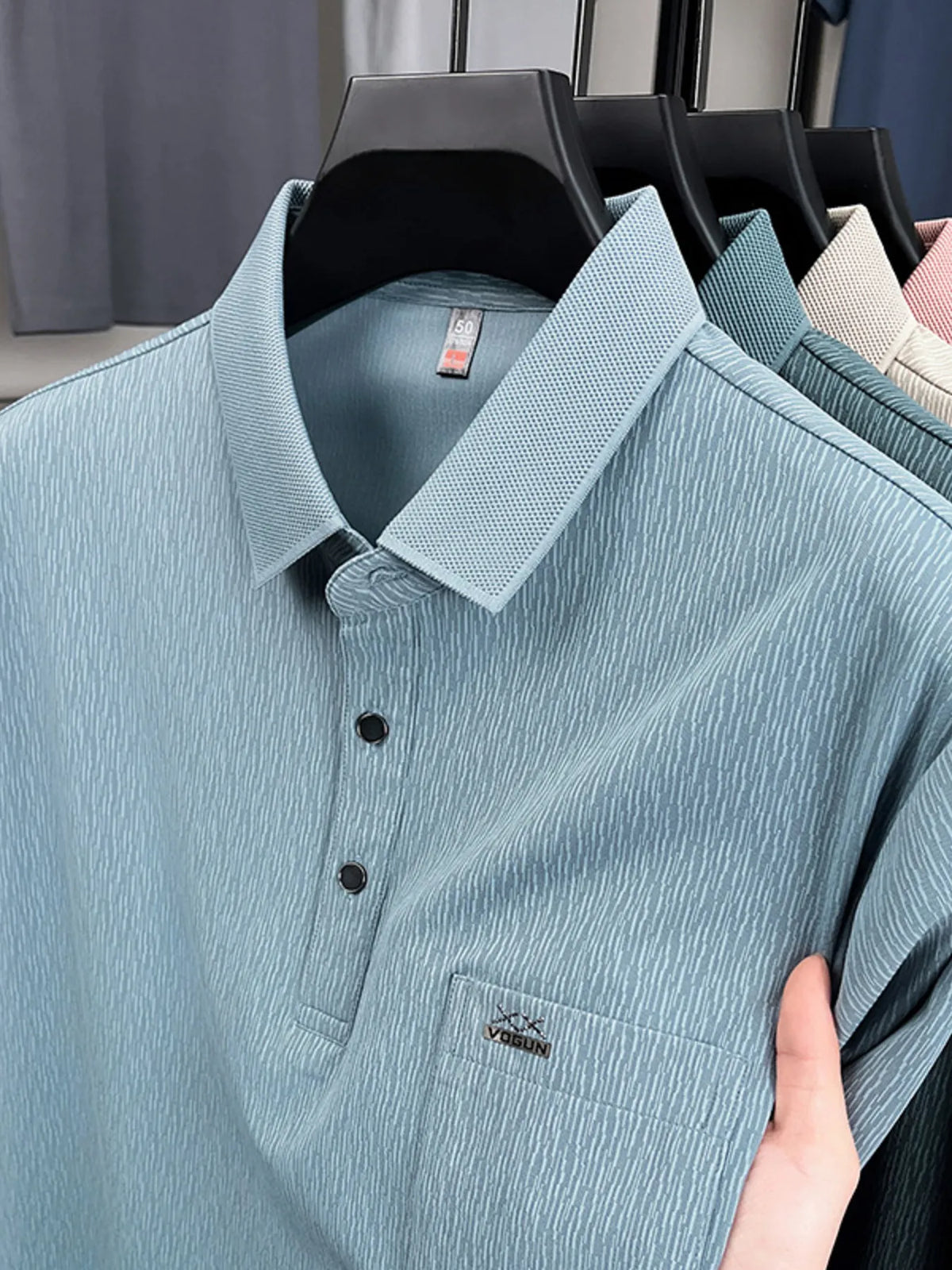 Light blue polo shirt on a hanger with visible brand logos-blackorvani.com
