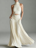 Woman wearing a flowing white dress against a gray background