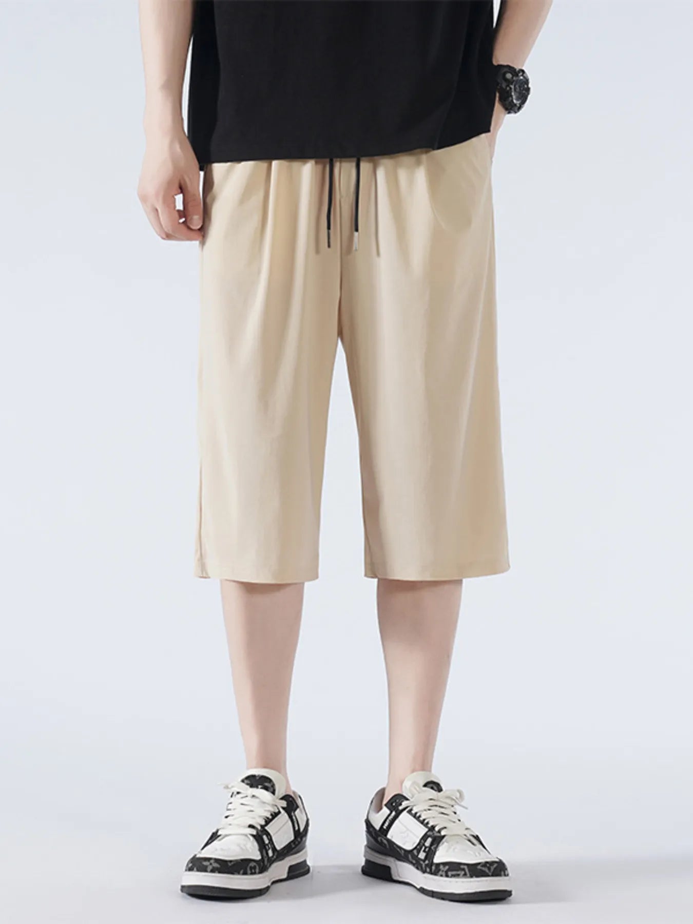 Person wearing beige shorts and black top on a white background-blackorvani.com