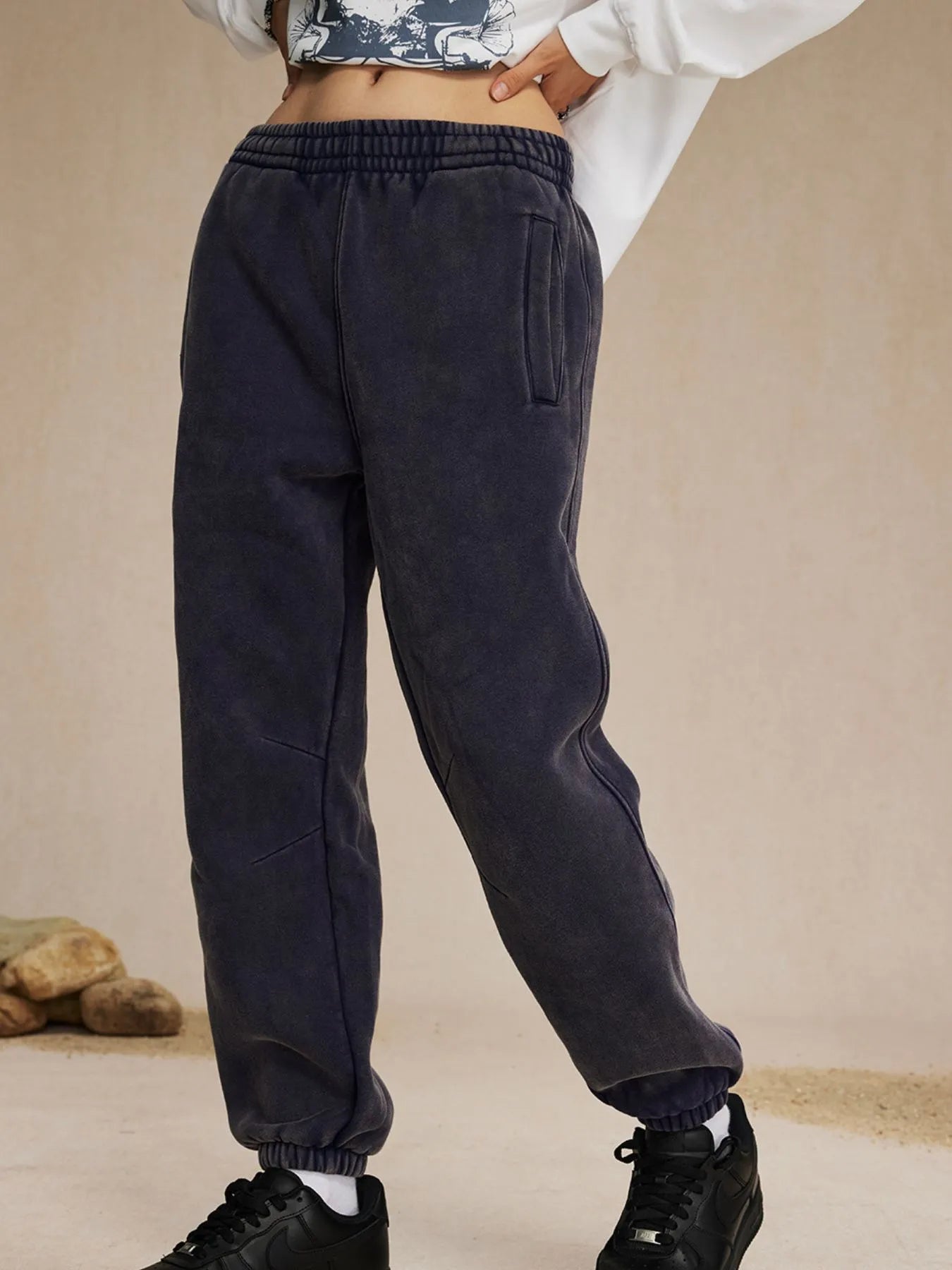 Person wearing dark gray sweatpants on a beige background-blackorvani.com