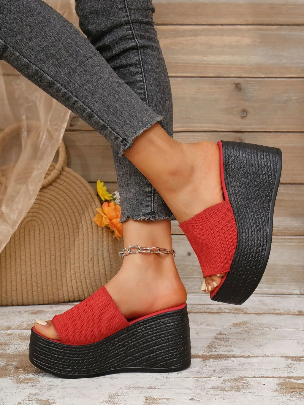 Red wedge sandals on a wooden floor with a blurred background
