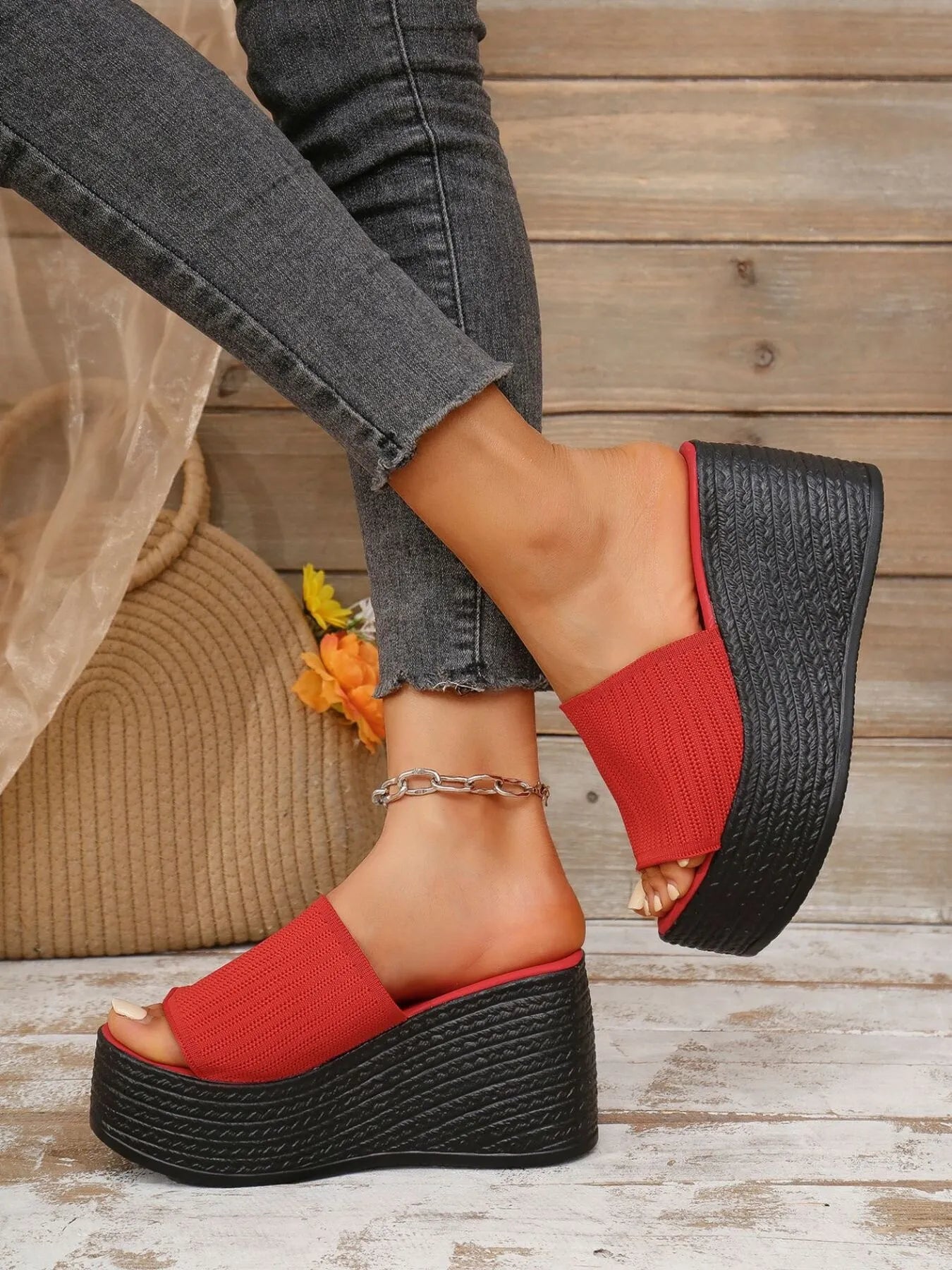 Red wedge sandals on a wooden floor with a blurred background