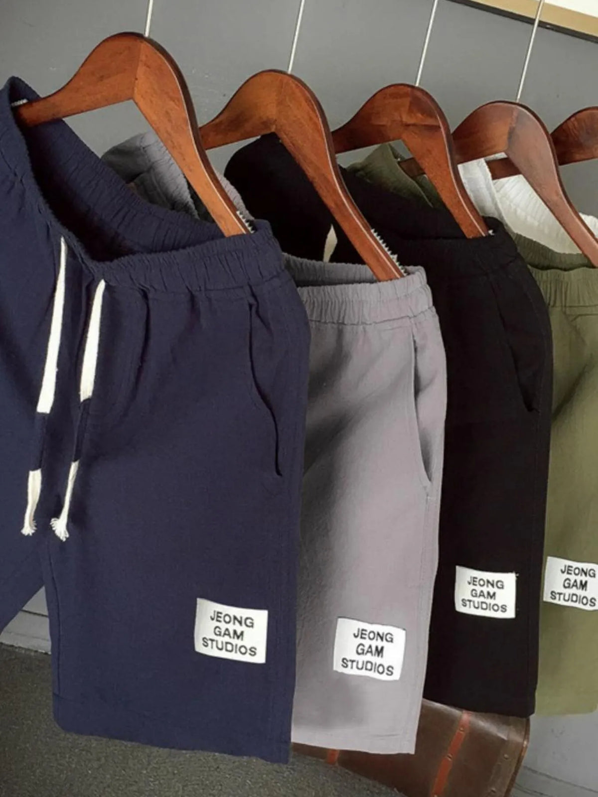Four pairs of shorts on hangers with 'JEONG GAM STUDIOS' labels, displayed against a neutral background.
