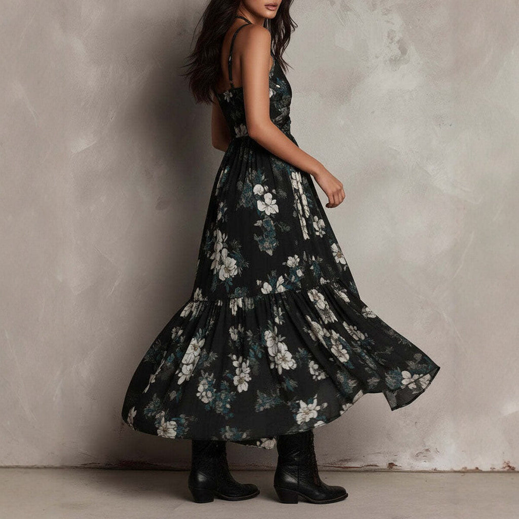 Woman wearing a black floral dress against a textured wall.