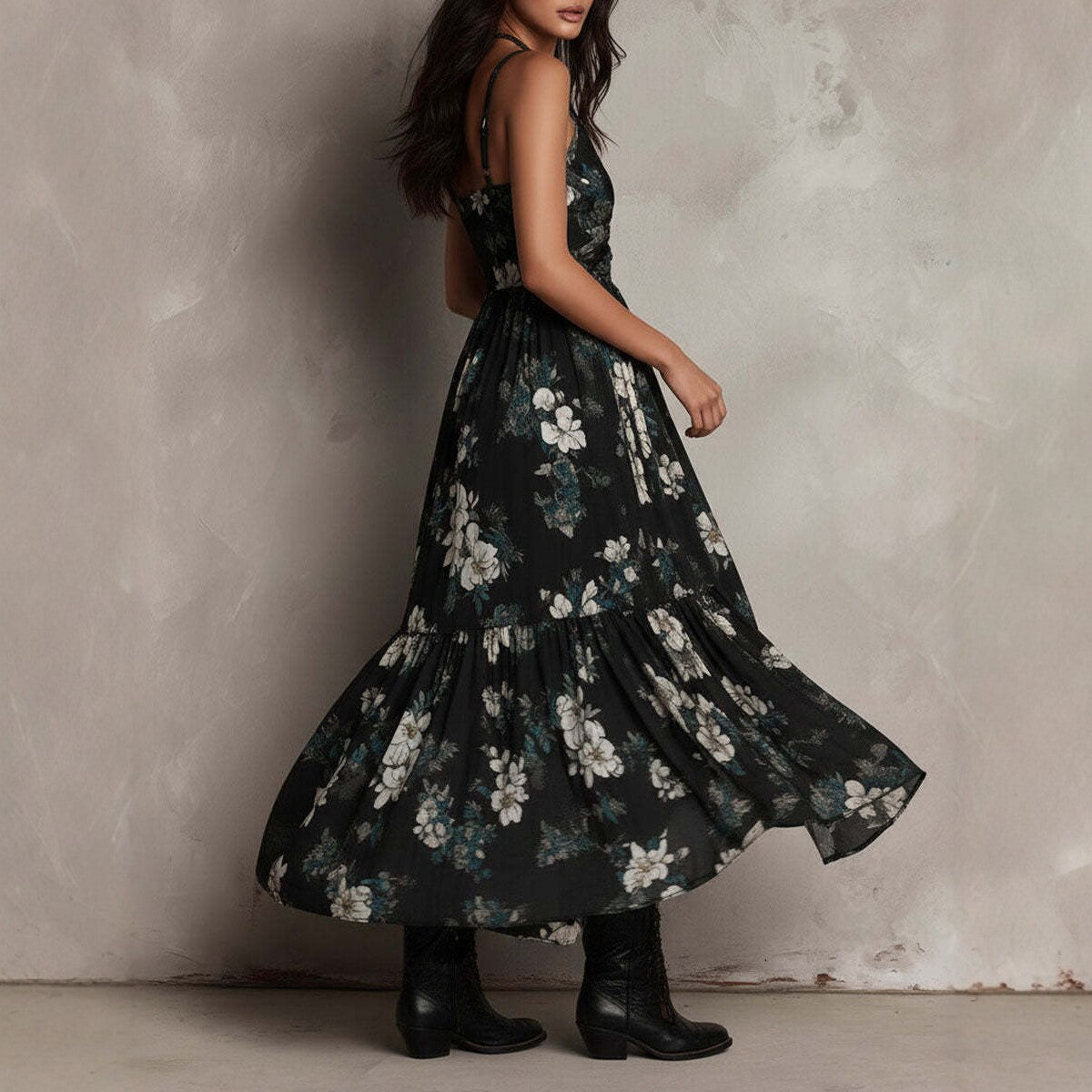 Woman wearing a black floral dress against a textured wall.