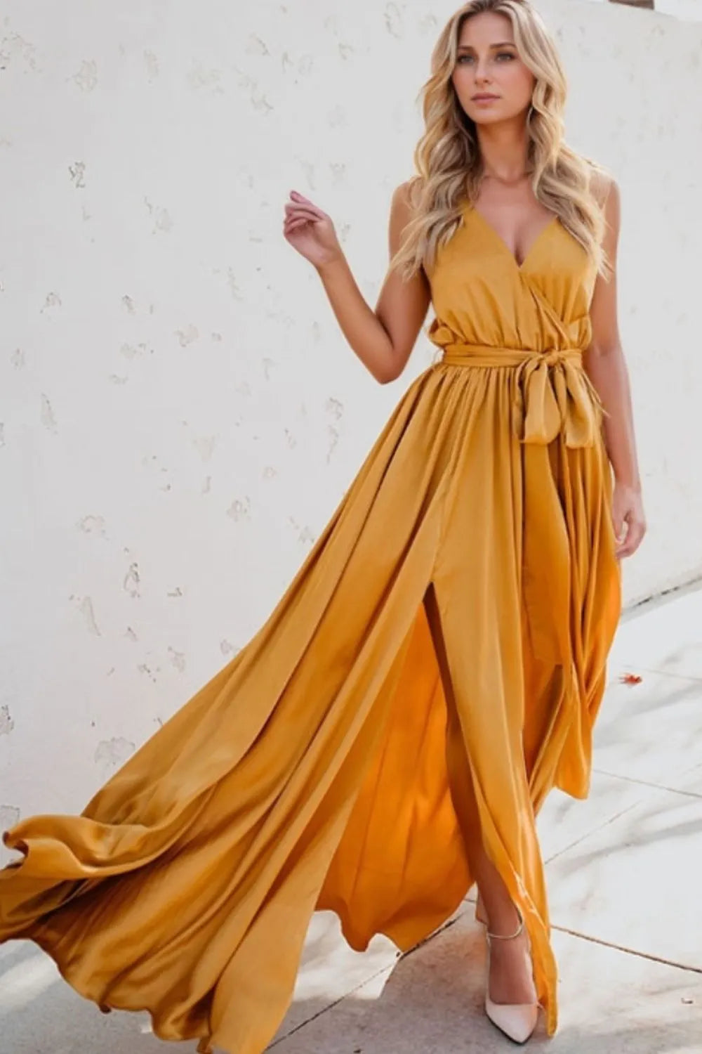 Woman wearing a flowing yellow dress against a white wall-blackorvani.com