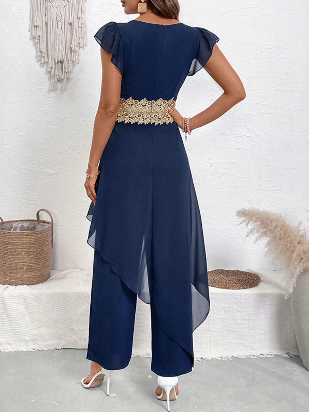 Navy blue dress with gold belt worn by a women, against a white wall-BlackOrvani