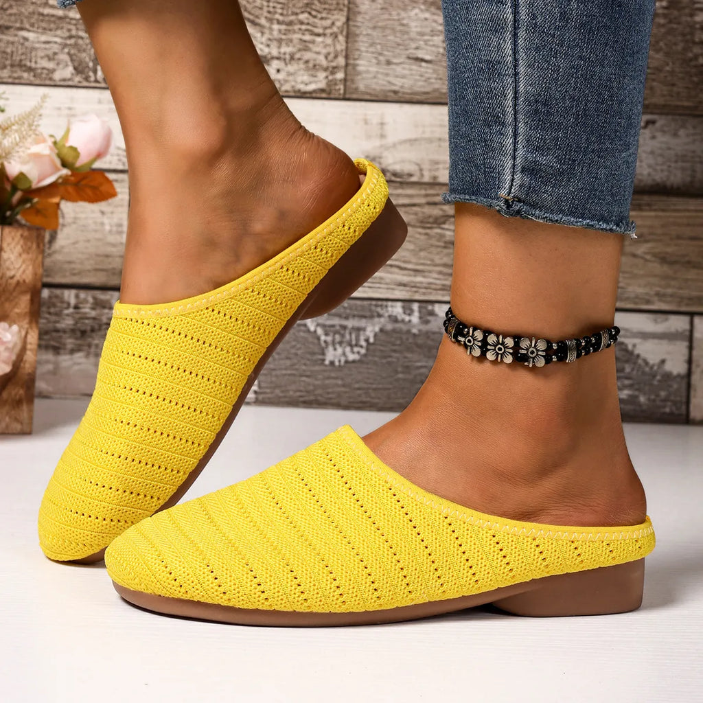 Yellow slippers worn with denim jeans on a wooden floor background
