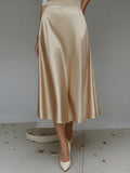 Beige satin skirt worn by a person on a plain background