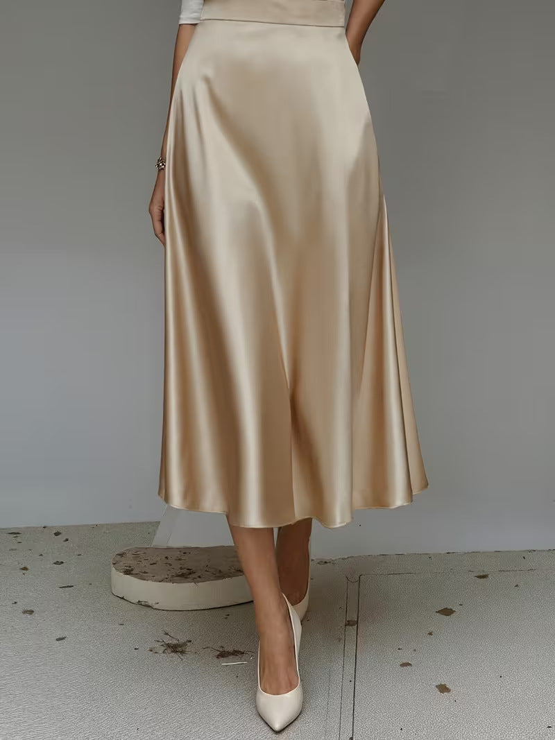 Beige satin skirt worn by a person on a plain background
