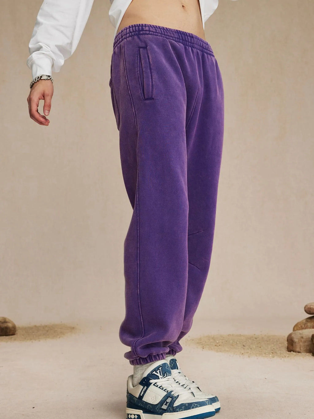 Purple sweatpants worn by a person on a beige background-blackorvani.com