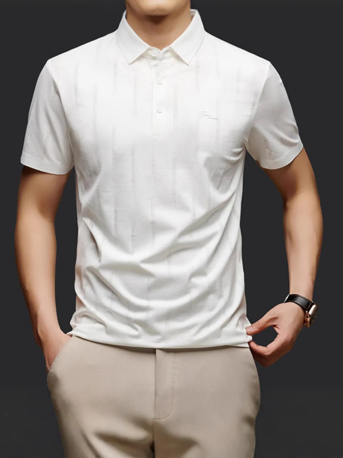 Person wearing a white short-sleeve shirt and beige pants on a dark background-blackorvani.com