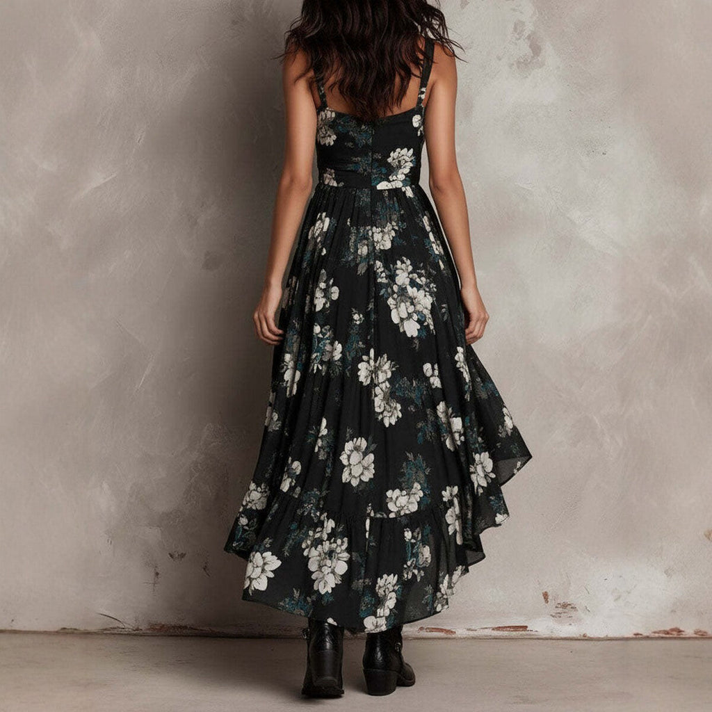 Woman wearing a black floral dress against a textured wall.
