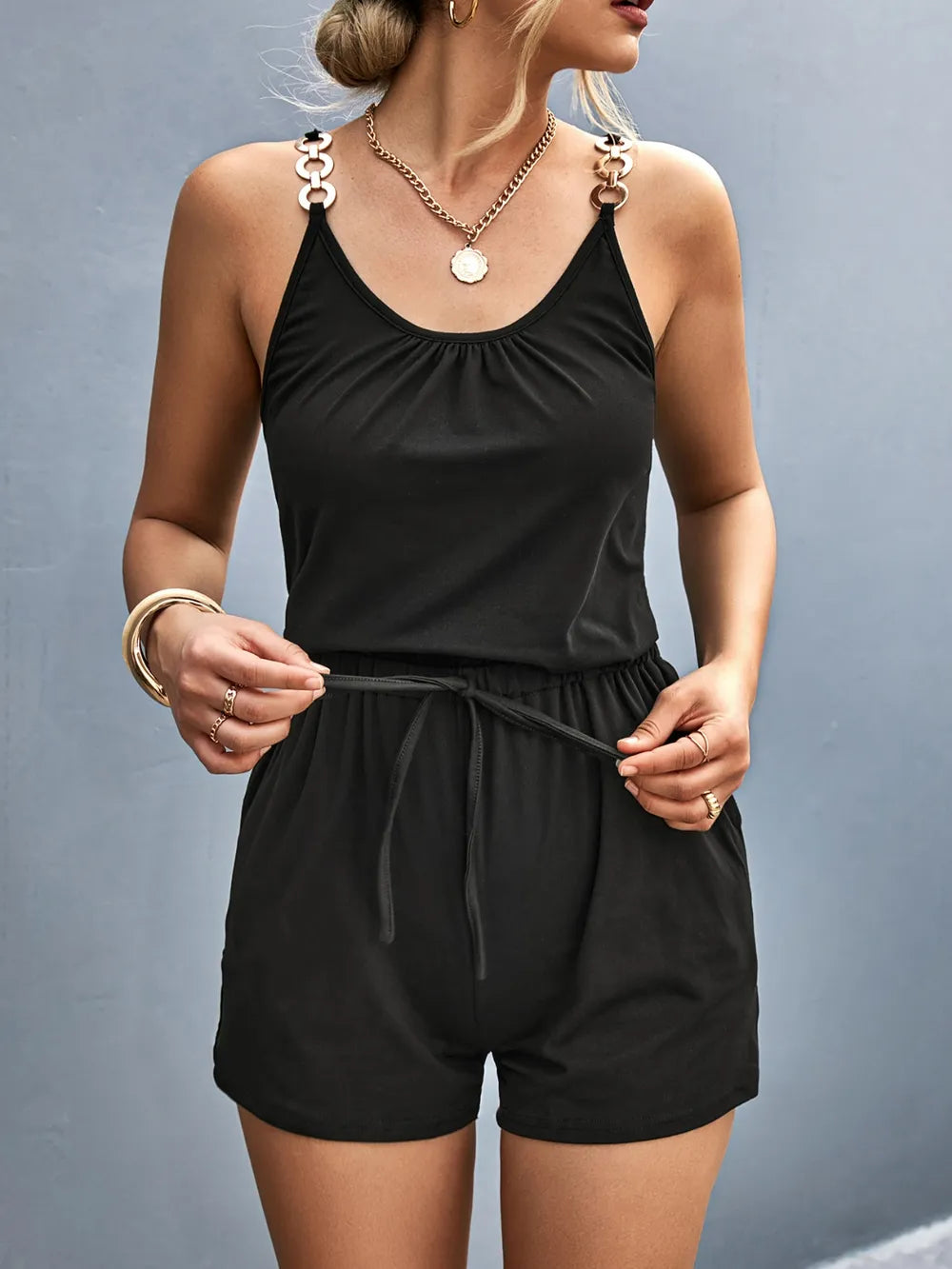 Woman wearing a black romper against a gray background-blackorvani.com