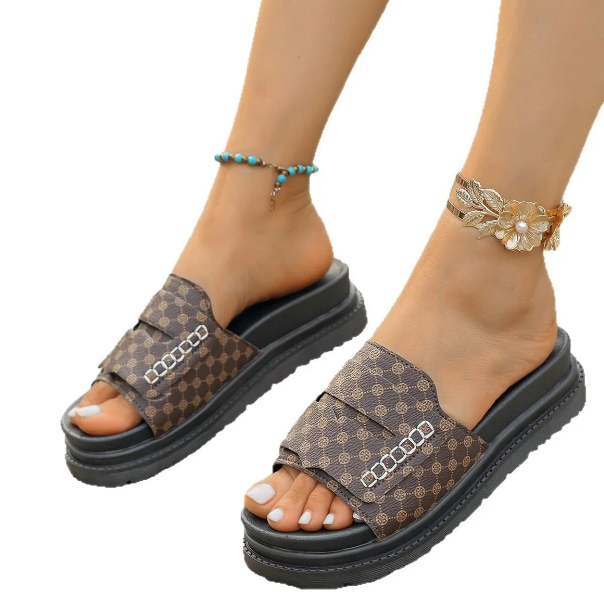 Brown patterned sandals worn on feet with a white background