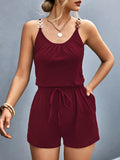 Woman wearing a burgundy romper against a gray background-blackorvani.com