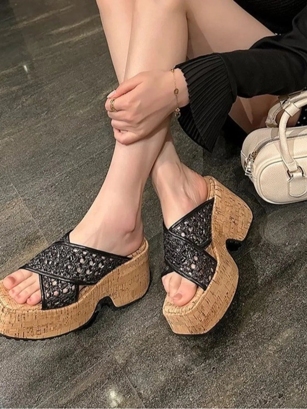 Person wearing black embellished sandals with cork soles on a stone floor-blackorvani.com
