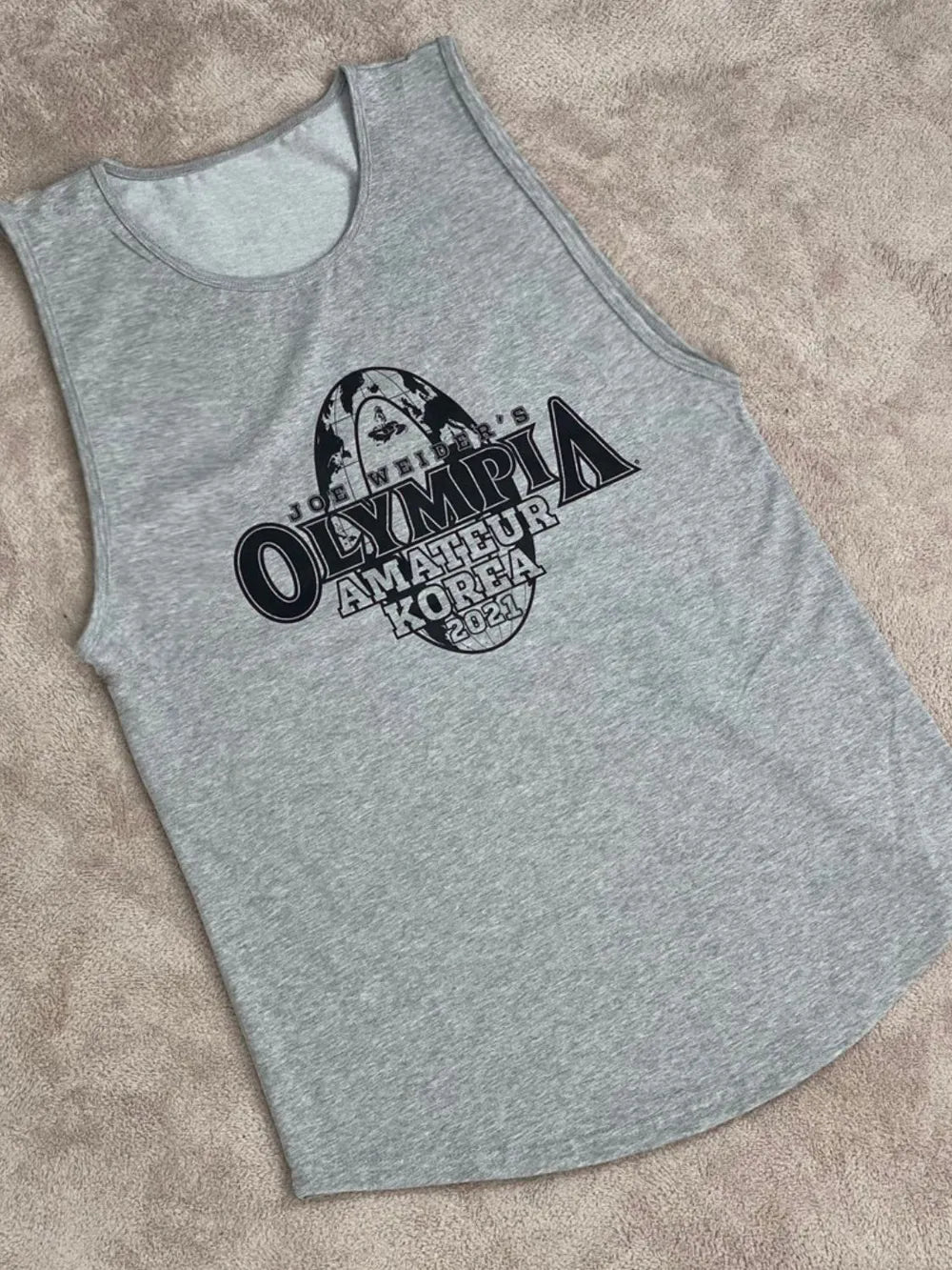Gray tank top with 'Olympia Amateur Korea 2020' text on a beige surface-blackorvani.com