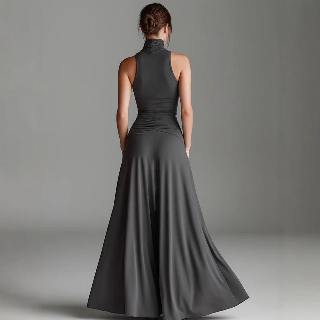 Woman wearing a long gray dress against a plain background