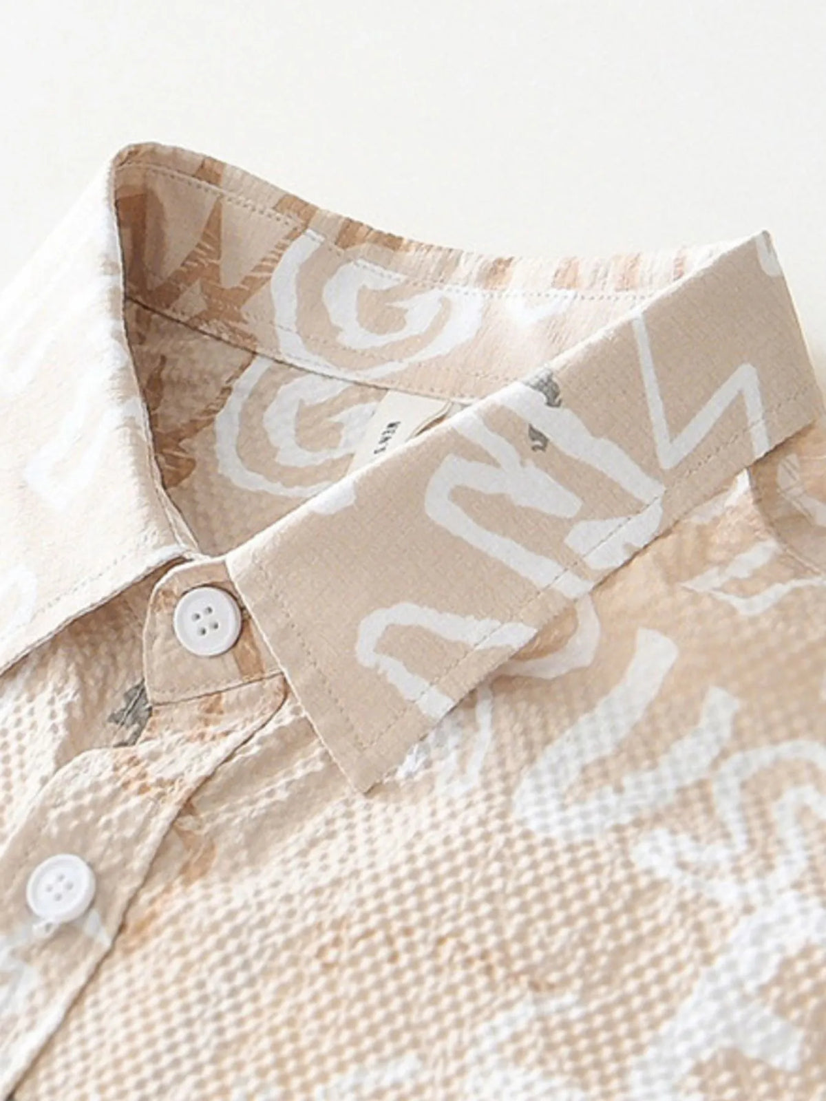 Close-up of a beige shirt with white patterns on a light background-blackorvani.com
