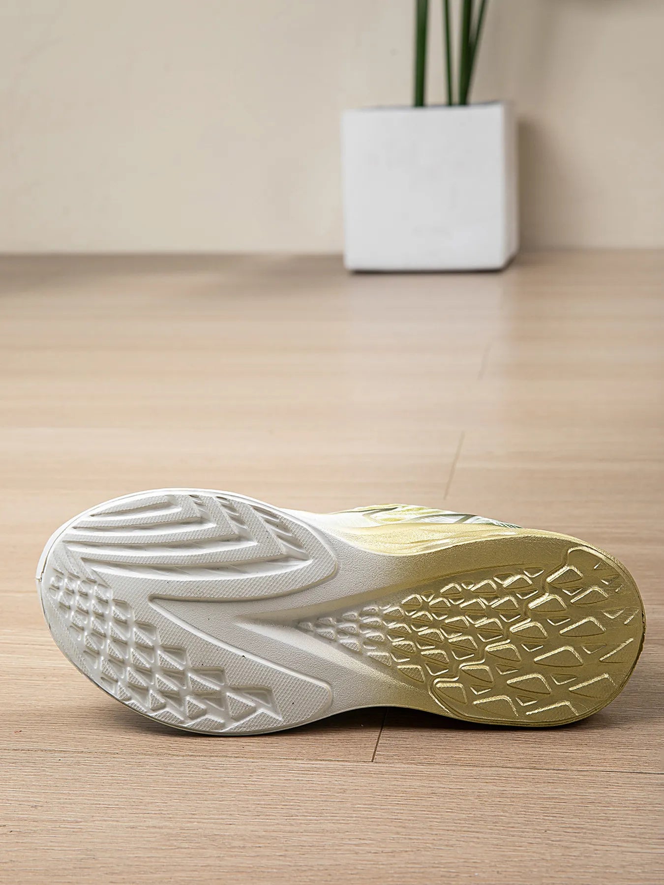 Close-up of a shoe sole with a textured pattern on a wooden floor.