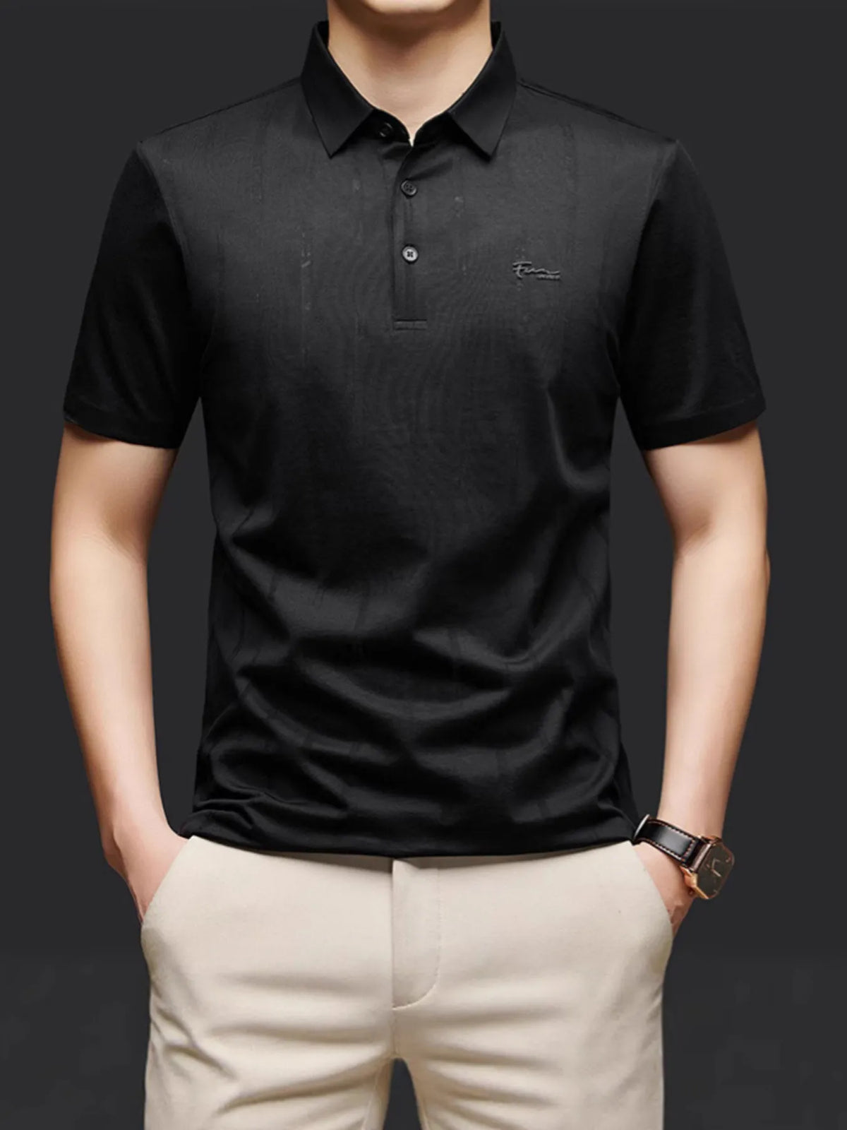 Person wearing a black polo shirt with a brand logo on a dark -background-blackorvani.com