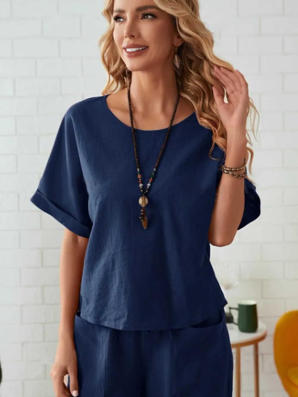 Woman wearing a navy blue outfit with a necklace in a casual setting-blackorvani