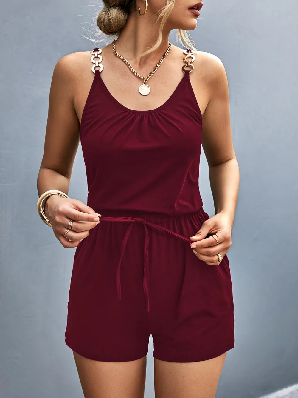 Woman wearing a burgundy romper against a gray background-blackorvani.com