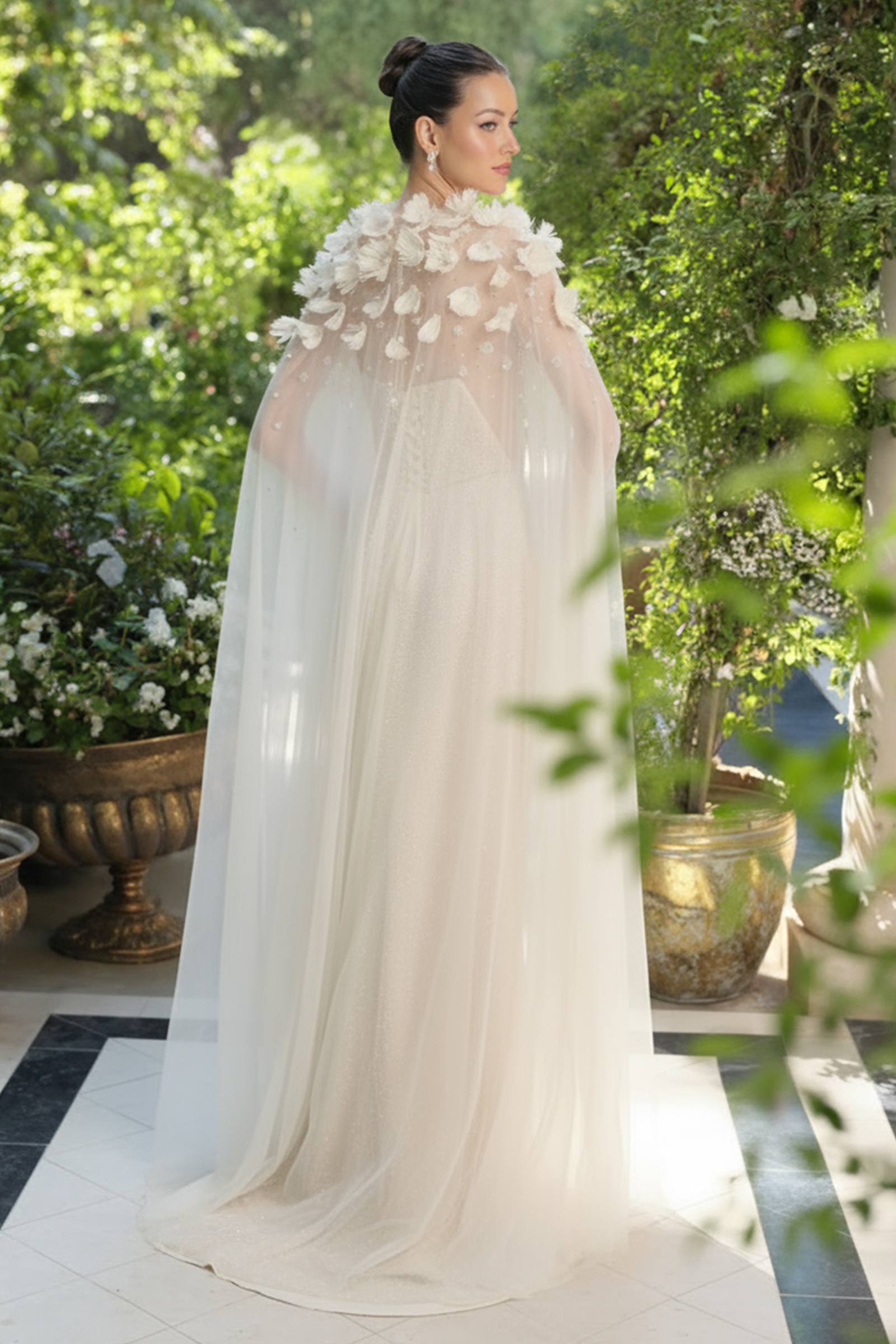 Woman in a white wedding dress with floral cape outdoors