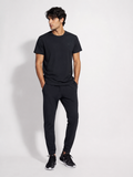 Men's black jogger pants worn by a male model with black sneakers on a clean studio background-BlackOrvani