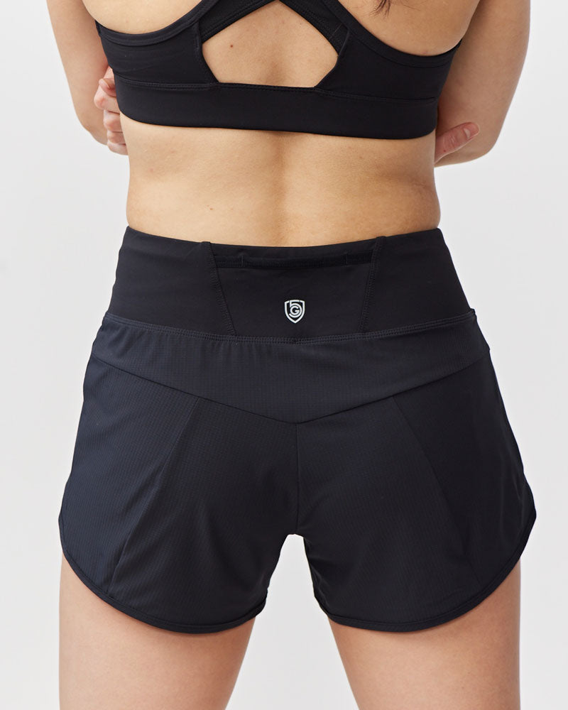 Black athletic shorts worn by a person on a light gray background