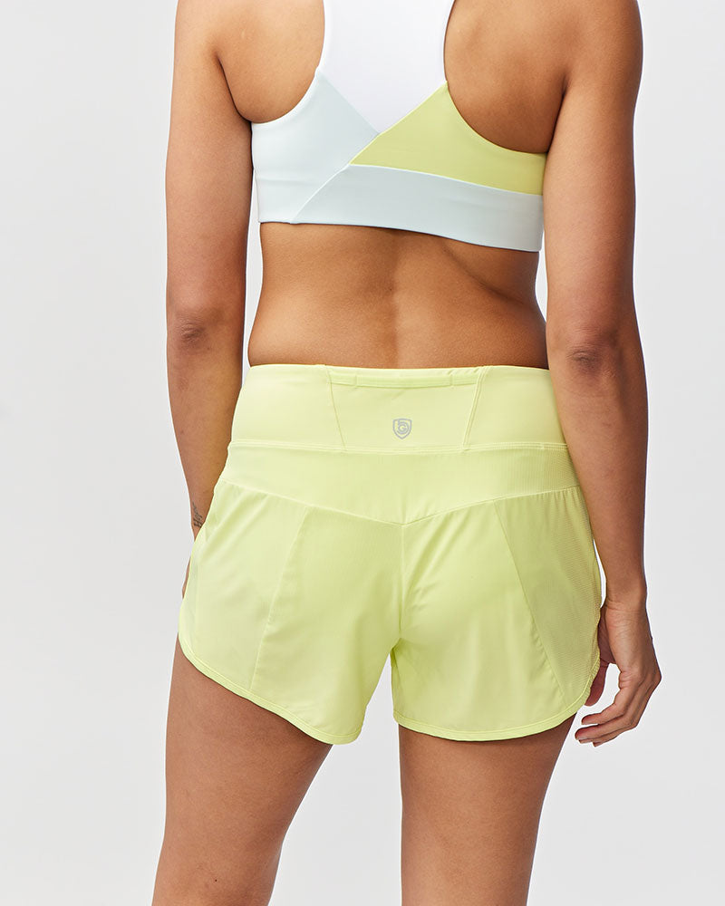 Person wearing light green athletic shorts on a plain background