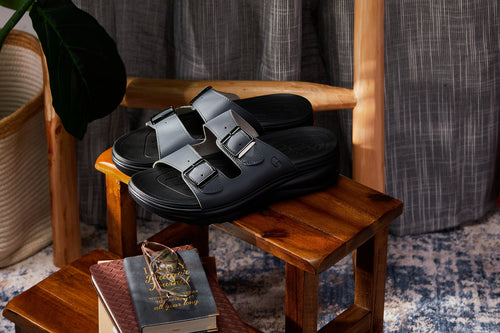Black sandals on a wooden stool with a book and decorative object in a room setting-blackorvani