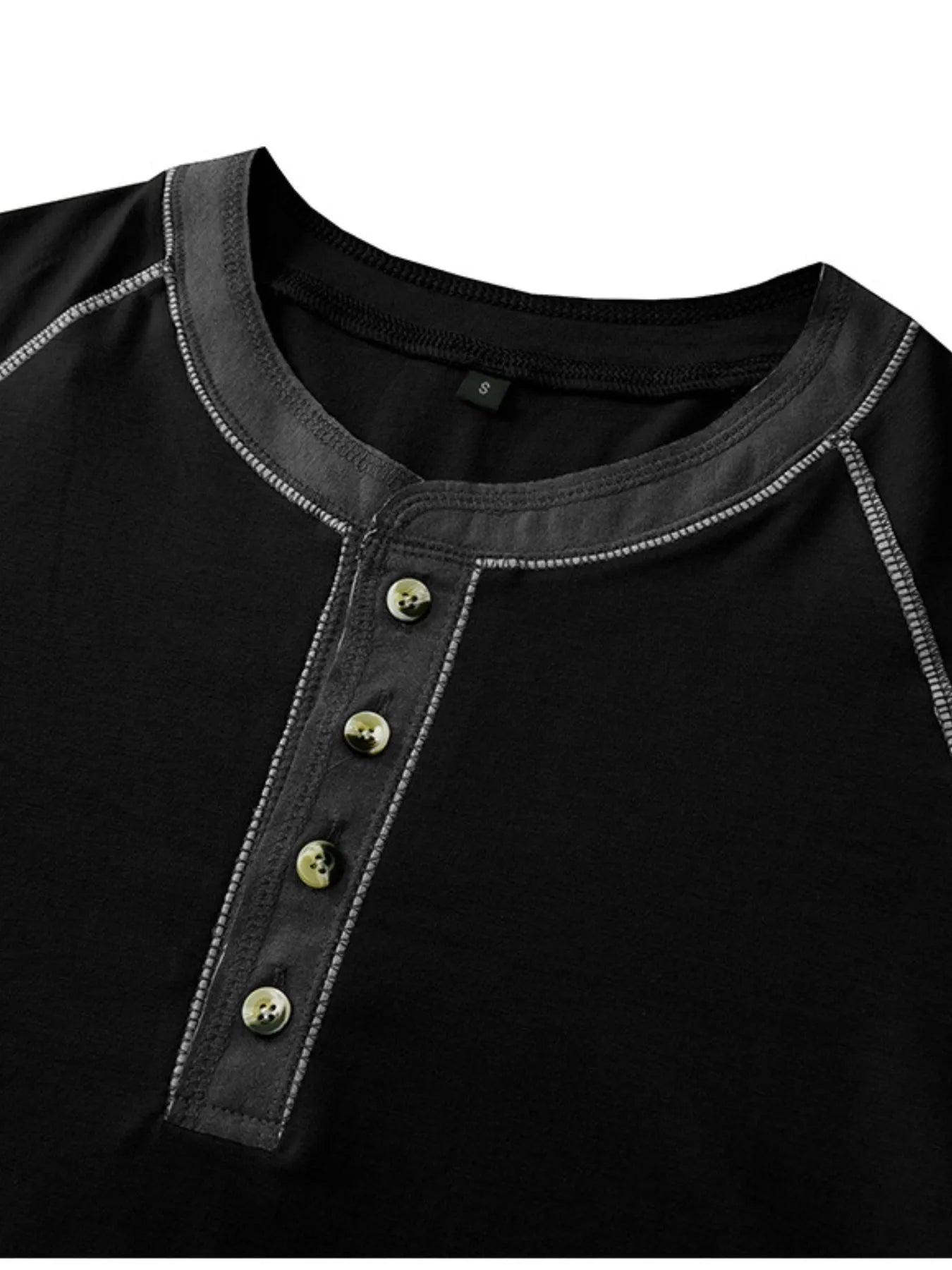 Close-up of a black shirt with button details on a white background