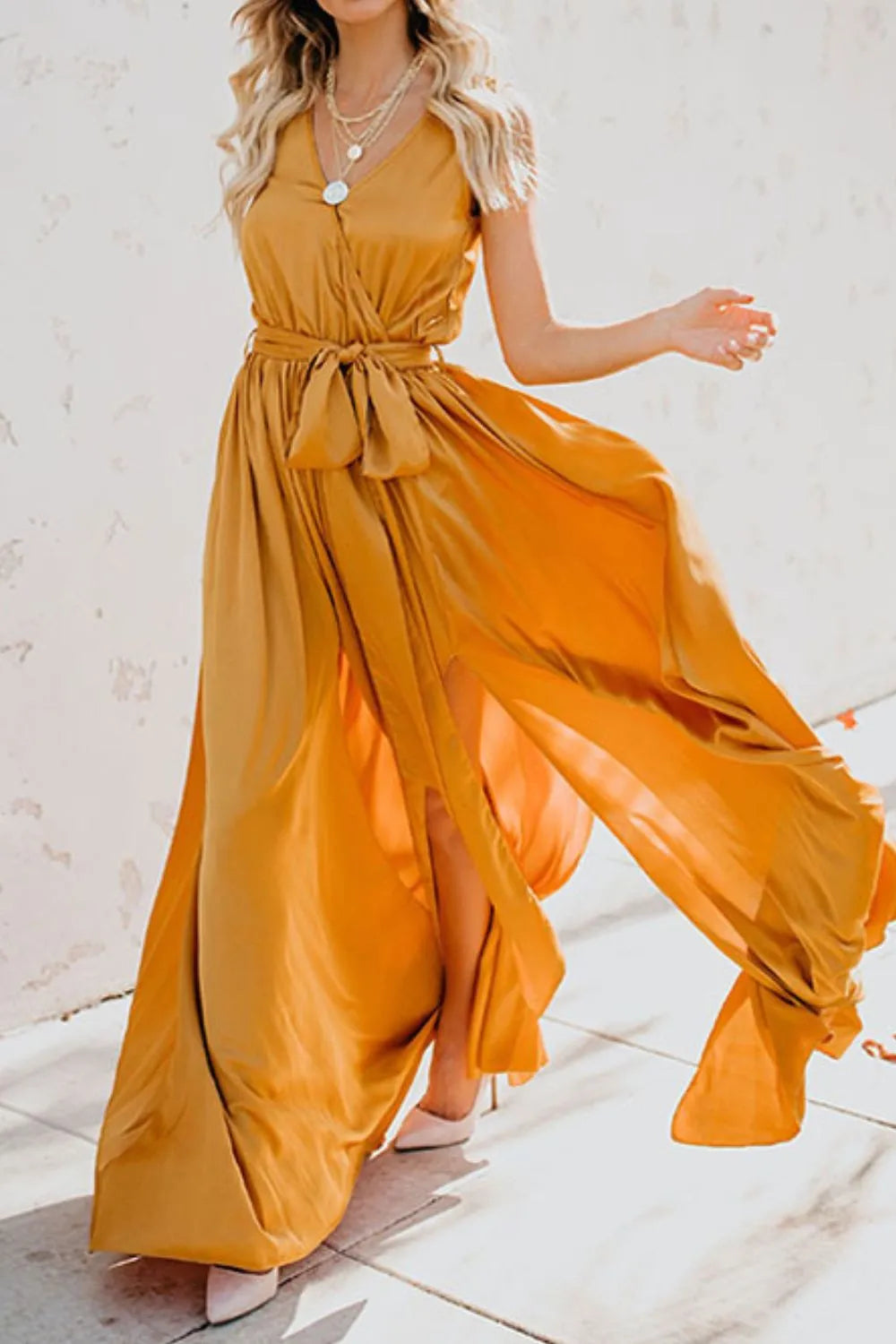 Woman wearing a flowing yellow dress on a light background-blackorvani.com