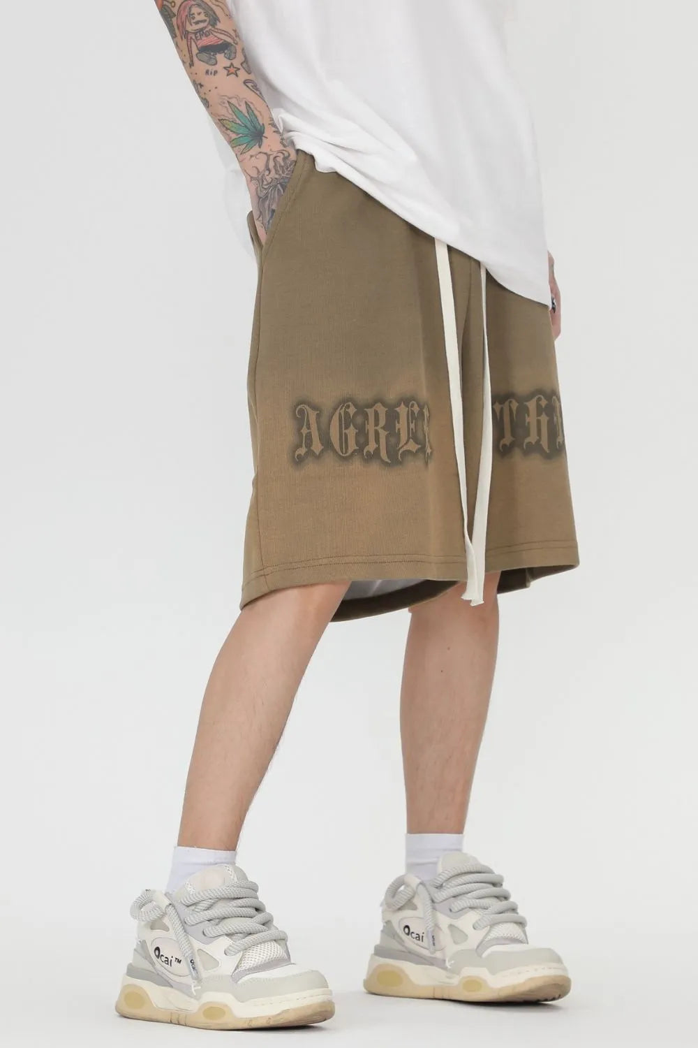men wearing a beige skirt with text, white sneakers, and white socks-Black Orvani