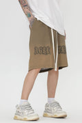 men wearing a beige skirt with text, white sneakers, and white socks-Black Orvani