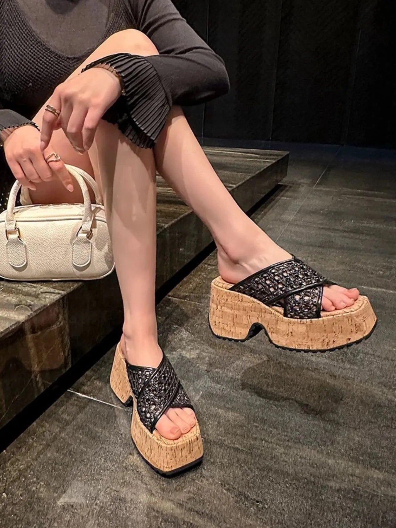 Person wearing black platform sandals with cork soles on a dark floor-blackorvani.com