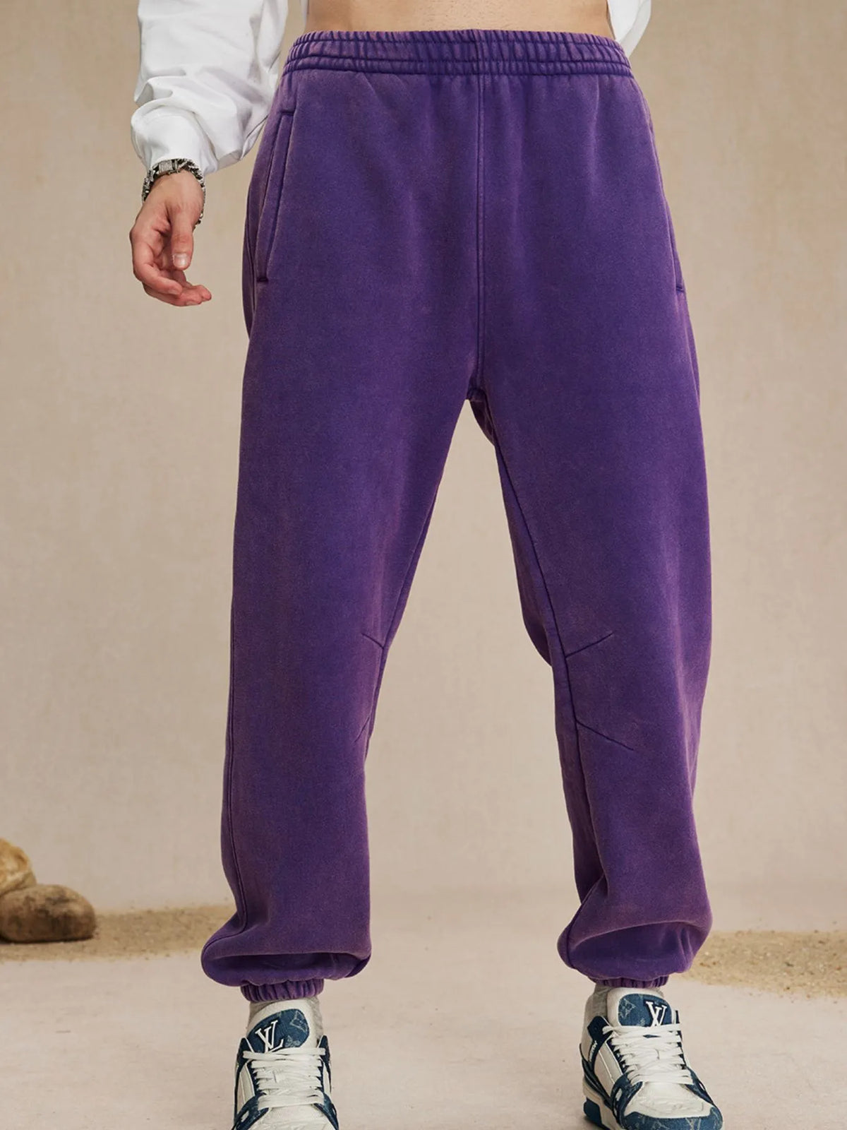 Purple sweatpants worn by a person on a beige background-blackorvani.com