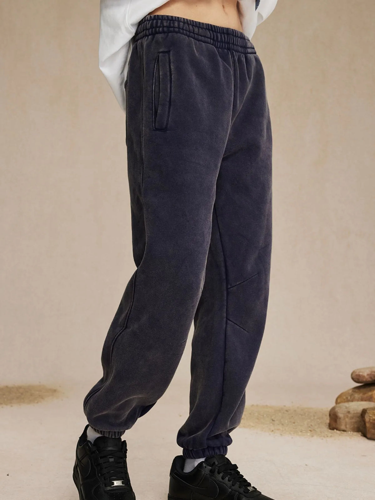 Dark gray sweatpants worn by a person on a beige background-blackorvani.com