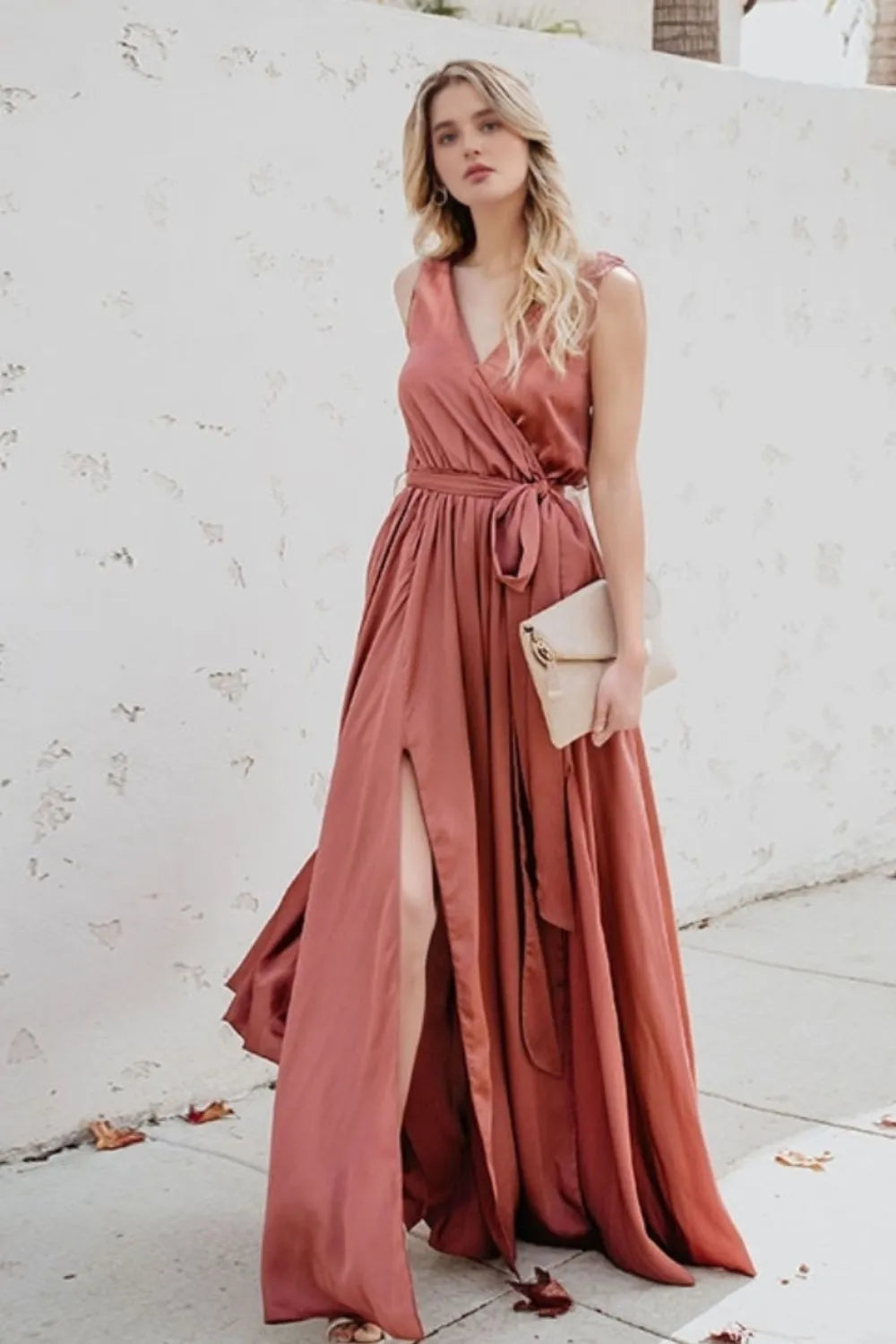 Woman in a long, flowing dress standing against a white wal-blackorvani.com