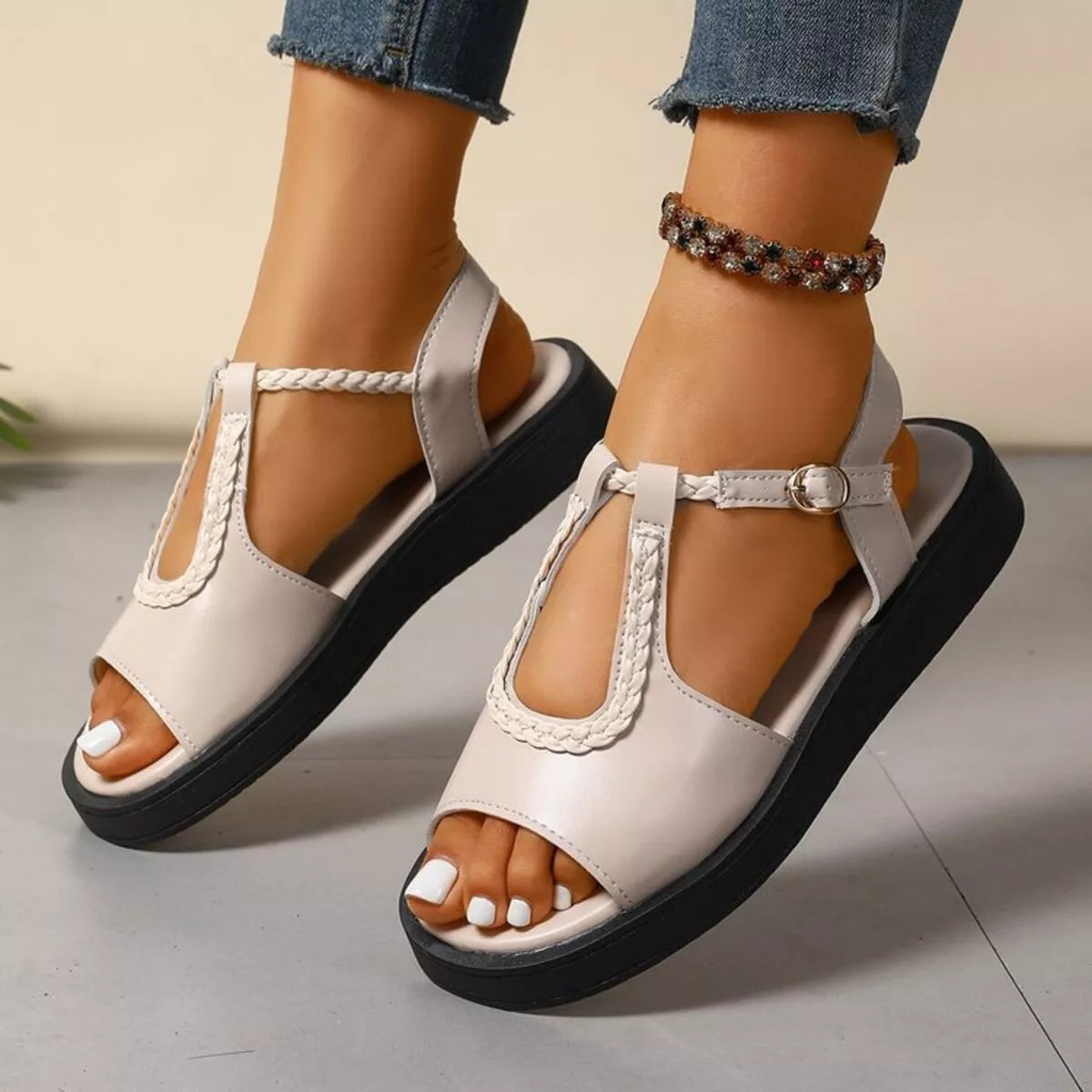 Beige sandals with black soles worn by a person on a neutral background-blackorvani.com