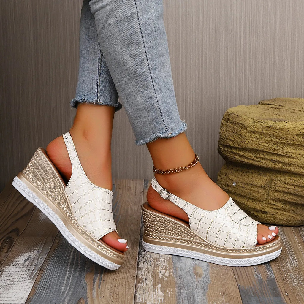 White wedge sandals worn with light blue jeans on a wooden floor-blackorvani.com
