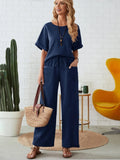 Woman in navy blue outfit standing in a room with a cactus plant and yellow chair-blackorvani